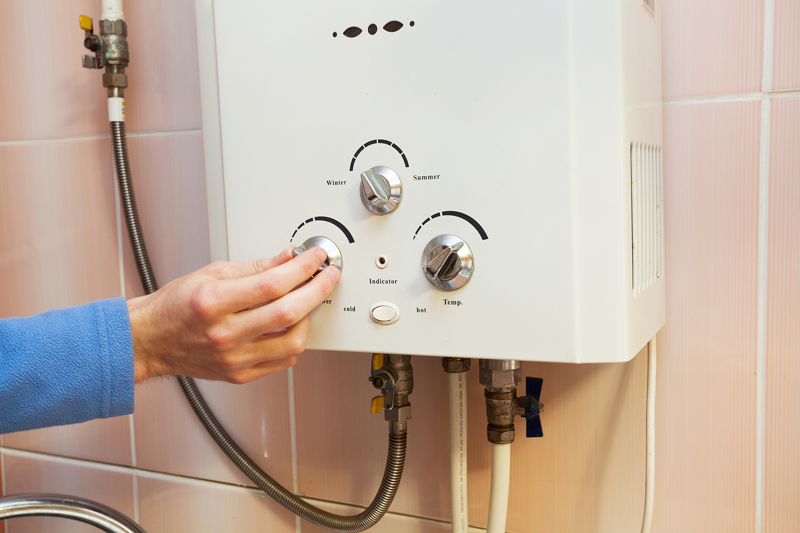 A hand while regulating the power of hot water in Gas water heater