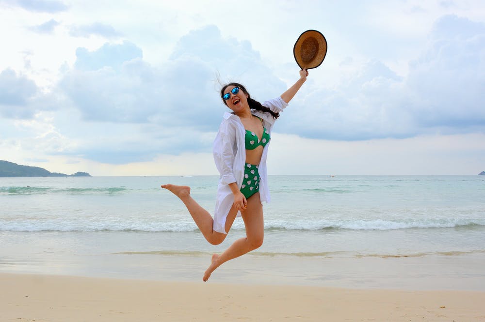 woman jumping while wearing high waisted thong bikini
